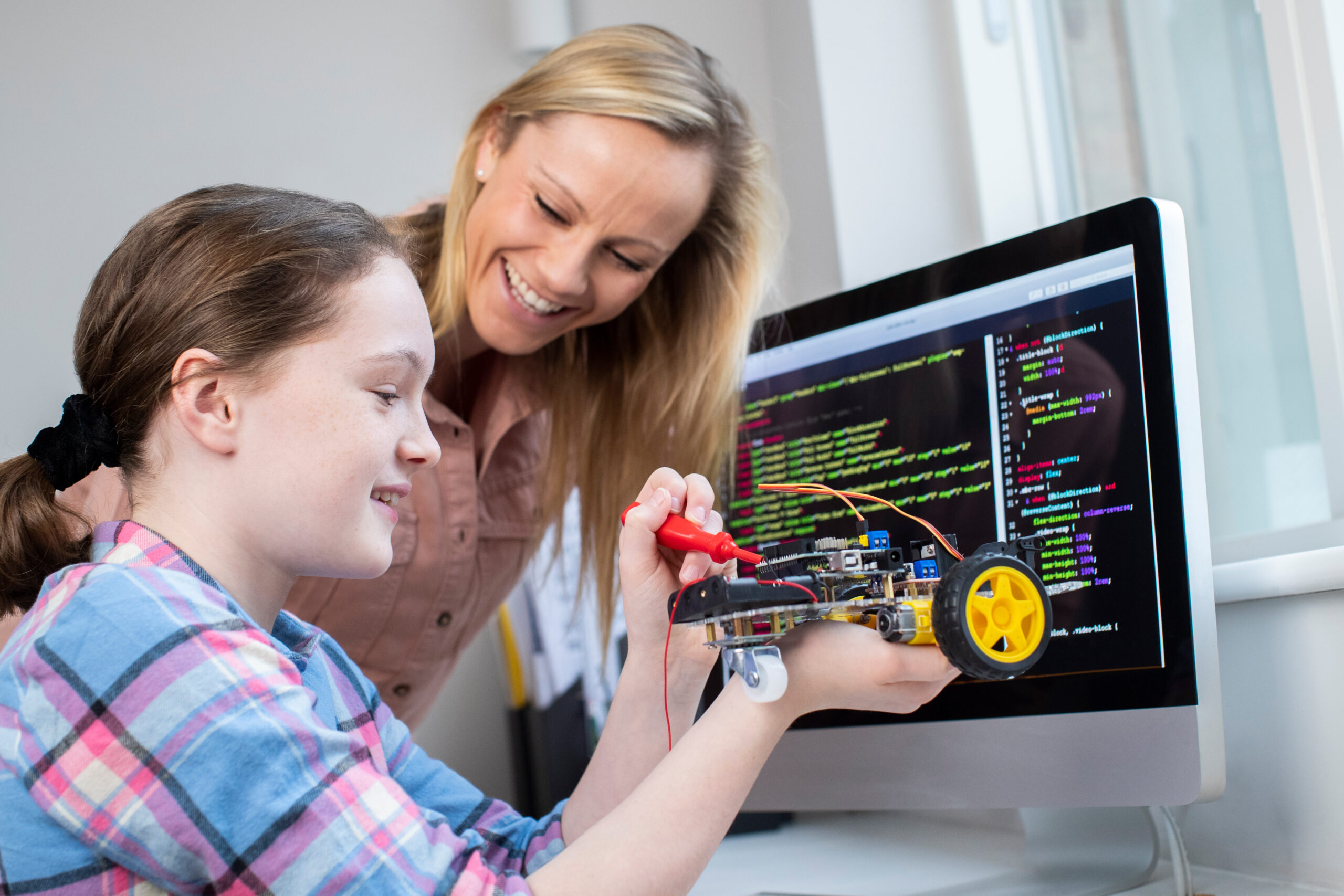 Female,Teacher,Helping,Girl,Building,Robotic,Car,In,Science,Lesson